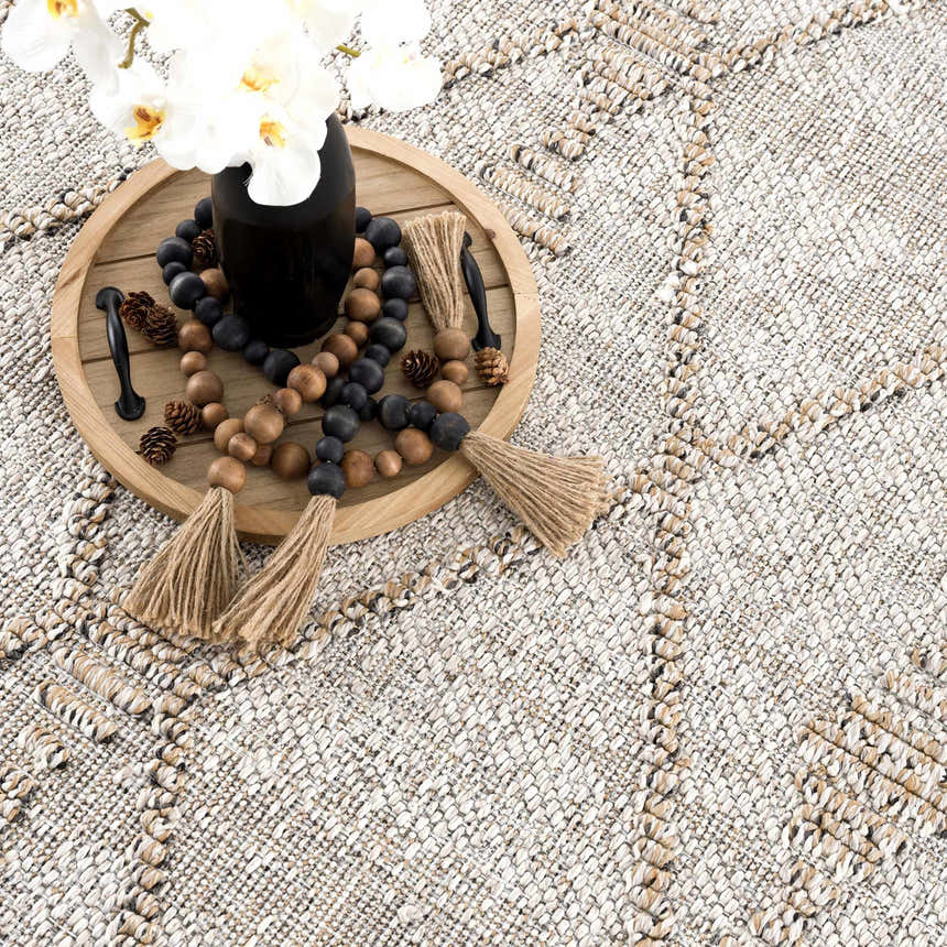 Close-up of the Nyla Bone & Tan Textured Performance Rug, a farmhouse style rug with a woven design. Styleshot