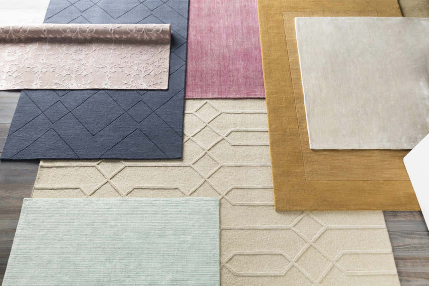 Various contemporary rugs including the Millinocket Area Rug in dusty pink viscose, hand-loomed with geometric patterns. Styleshot