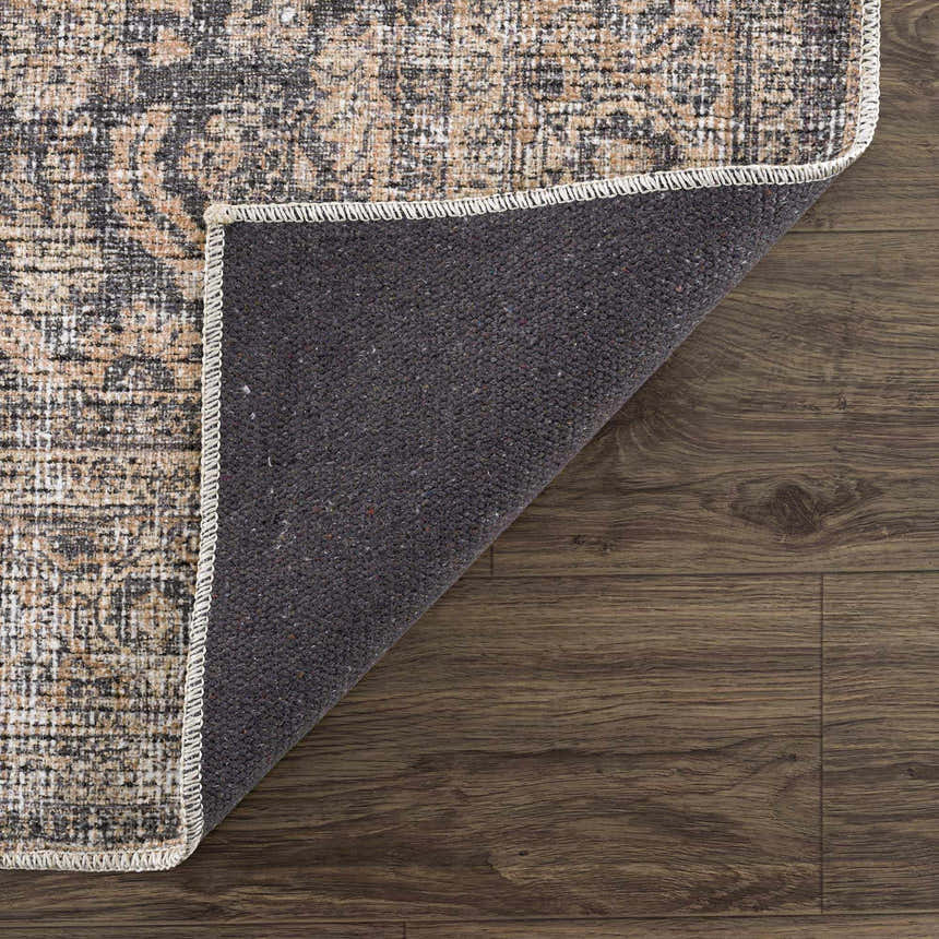 Close-up of the Orsin Washable Area Rug showing the traditional pattern, neutral colors, and the rug's backing. Fold