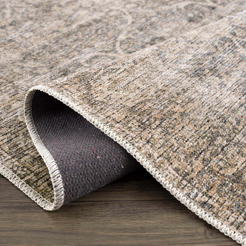 Close-up of Ohoud Washable Area Rug showing texture, neutral colors, traditional pattern, and machine-woven construction. Fold