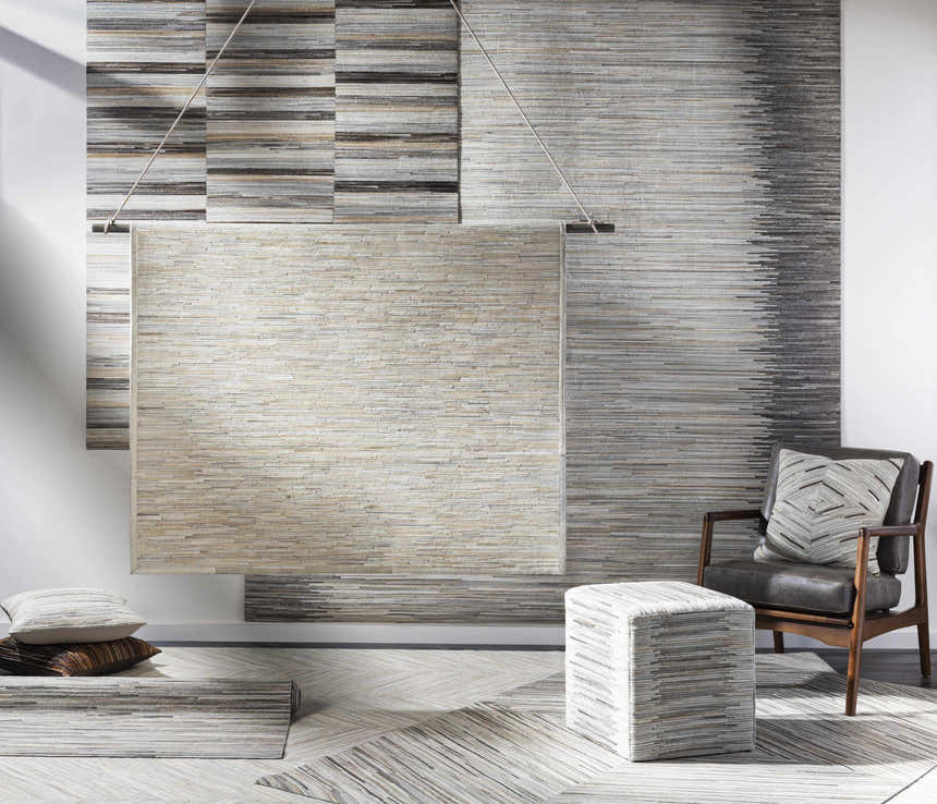Contemporary room scene with brown leather chair, ottoman, and Upland Premium Rug in cream, brown, and gray. Styleshot