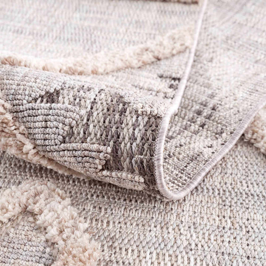 Close-up of the Serkomen High-Low Area Rug showing its woven texture, neutral colors, and high-low pile design. Fold