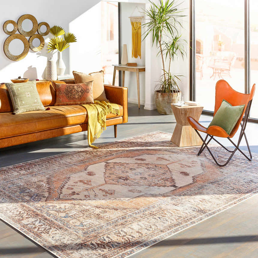 Living room scene with a brown leather sofa and Arncliffe Washable Area Rug in brown, tan, and ivory tones. Roomscene-Rectangle