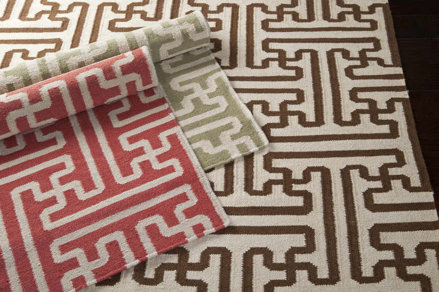 Close-up of Bentonville Area Carpet in brick red, tan, and sage. Hand woven wool rug with a contemporary geometric pattern. Styleshot