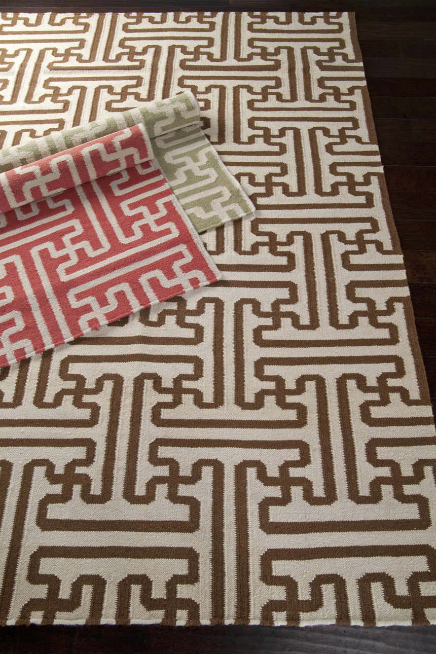 Bentonville Area Carpet, a hand-woven wool rug with a geometric pattern in brick red, tan, and brown on dark wood floors. Styleshot