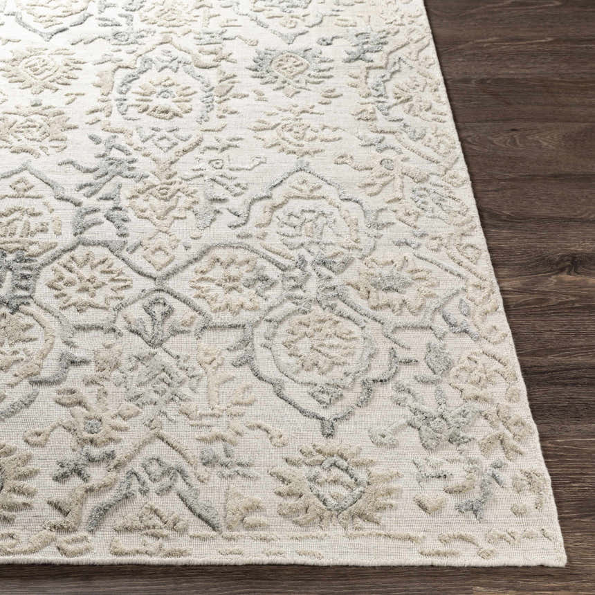 Close-up of the Acle Area Rug showing its raised, textured floral and geometric pattern in cream, beige, and gray. Front