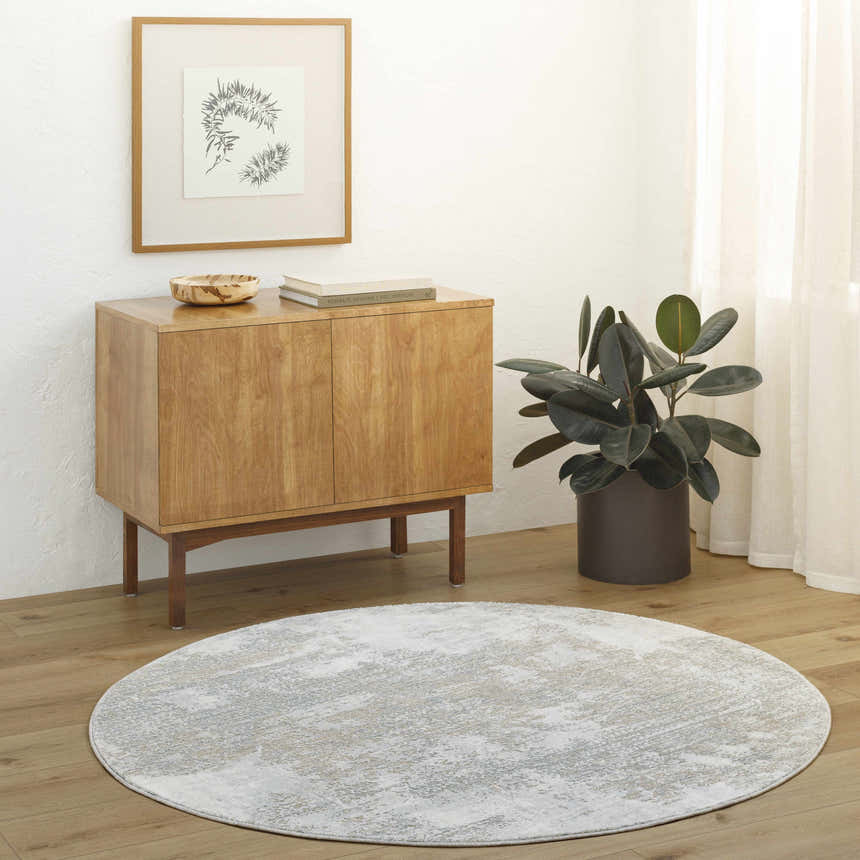 Minimalist living room scene with a round Adwoa Boutique Rug in gray, wood cabinet, plant, and light wood floors. Roomscene-Round