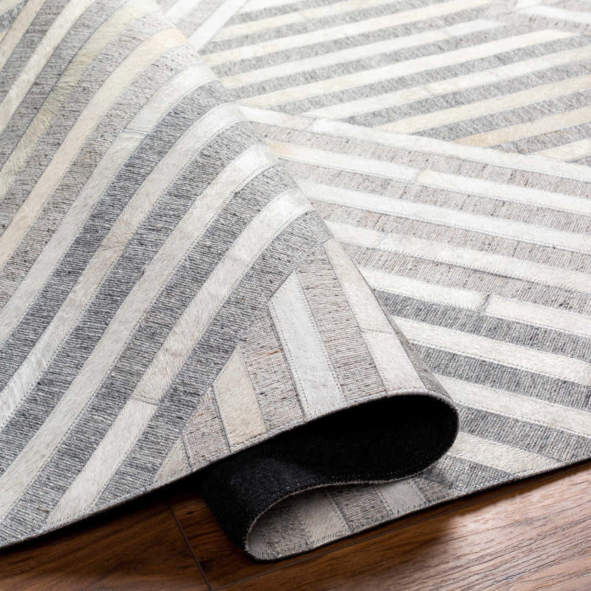 Close-up of the Akiye Area Rug showing beige, cream, and gray geometric stripes and hand-crafted texture. Fold