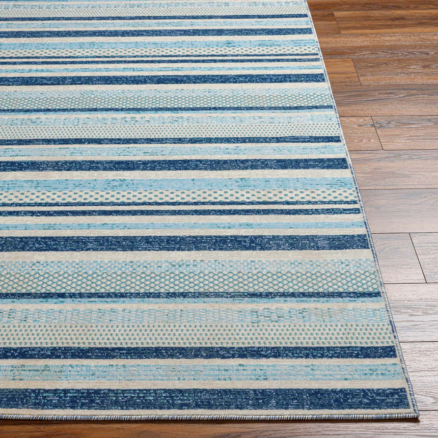 Close up of the Alain Area Rug, featuring a blue and white striped geometric design on a wood floor. Front