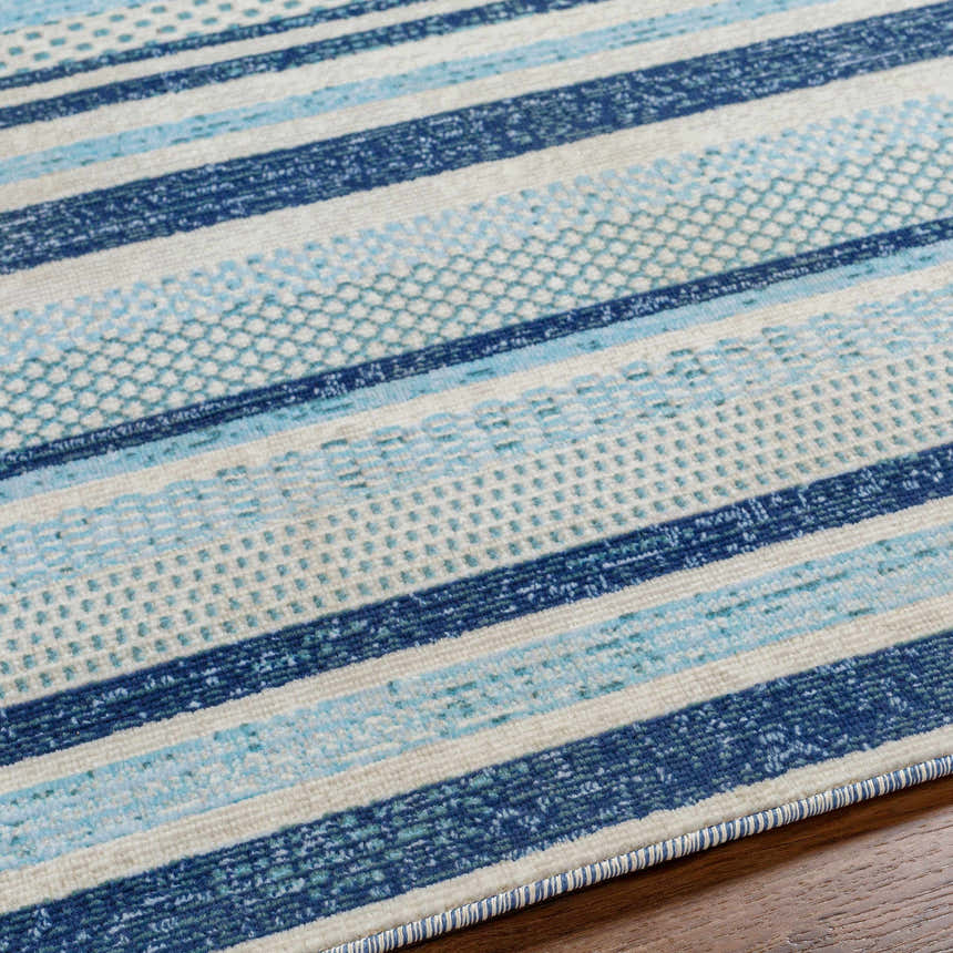 Close-up of the Alain Area Rug, featuring a coastal geometric design with blue and white stripes. Texture
