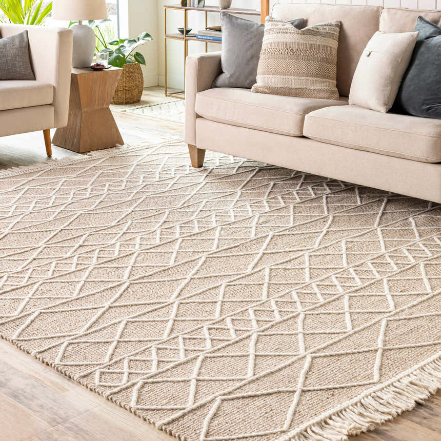 Living room scene with a cream sofa and the Ambulong Area Rug in cream and tan with a geometric design. Roomscene-Rectangle