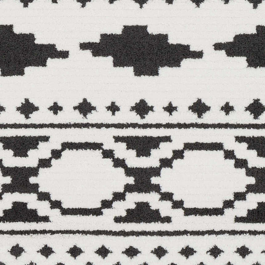 Close-up of Amoret Area Rug: black and off-white geometric pattern, machine woven texture. Bohemian style. Swatch