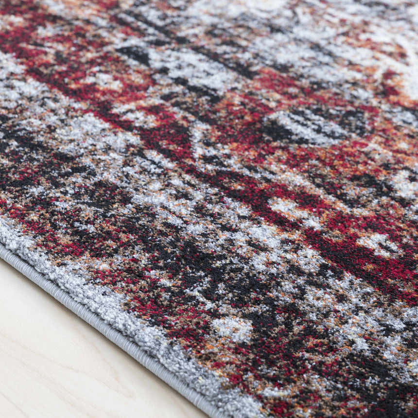 Close-up of the Analisa Area Carpet showing the black, burgundy, gray, ivory, orange, and yellow pattern and texture. Texture
