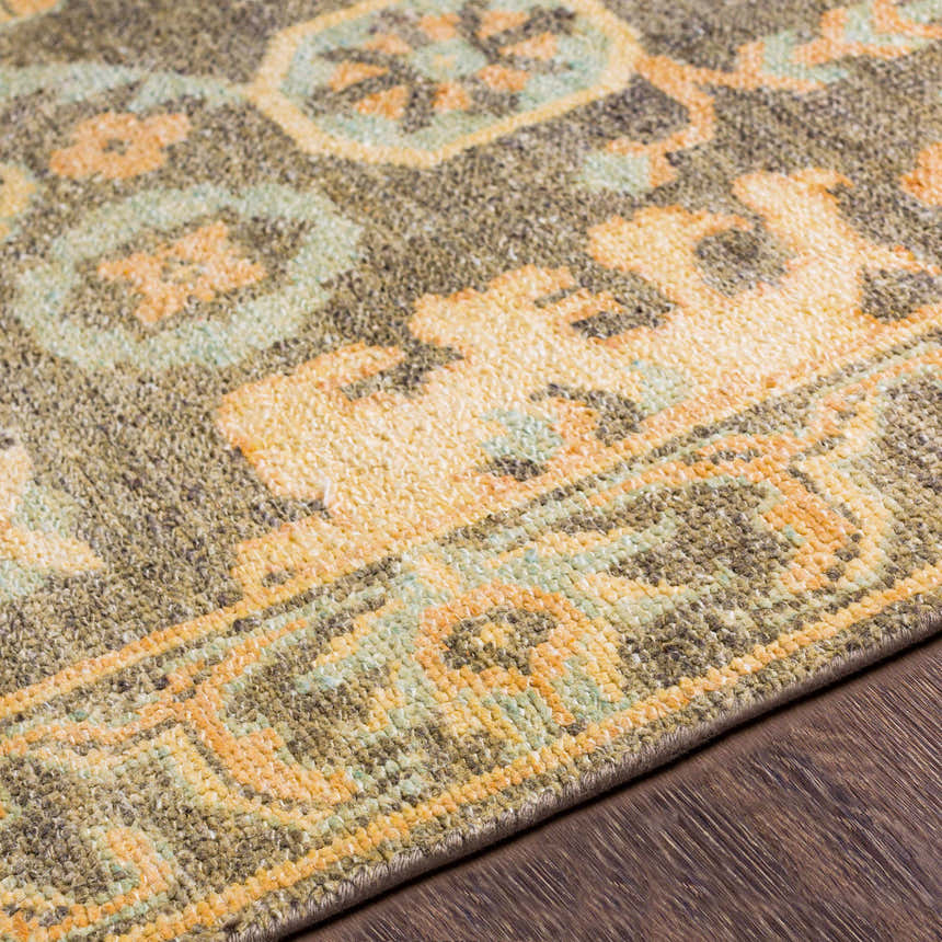Close up of the Asotin hand knotted wool rug. Burnt orange, charcoal, mustard, and olive tones. Texture