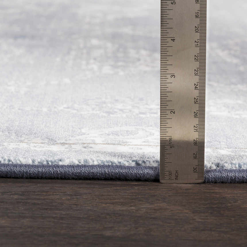 Close-up of Astatula Area Rug showing the rug's pile height and construction. Colors are blue, ivory, and light gray. Pile