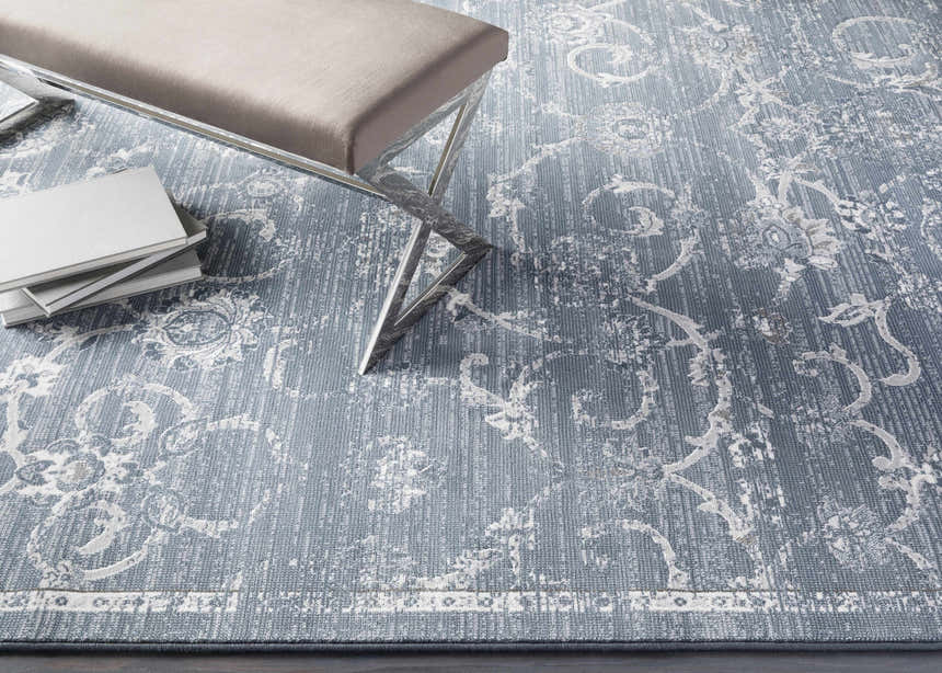 Close-up of the Astatula Area Rug, a blue and ivory vintage style rug with a traditional floral pattern. Styleshot