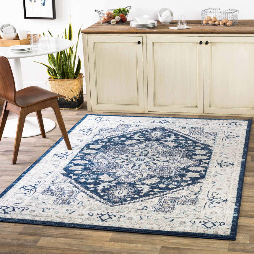 Kitchen scene with Aylsham Area Rug in charcoal, gray, navy, peach, and sky blue under a round table and neutral cabinet. Roomscene-Rectangle