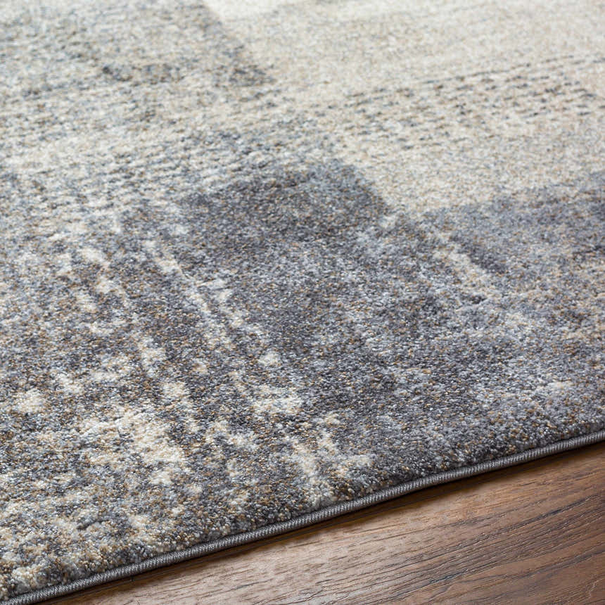 Close up of the Bacca Area Rug showing its gray, light gray, and brown abstract pattern and soft texture. Texture