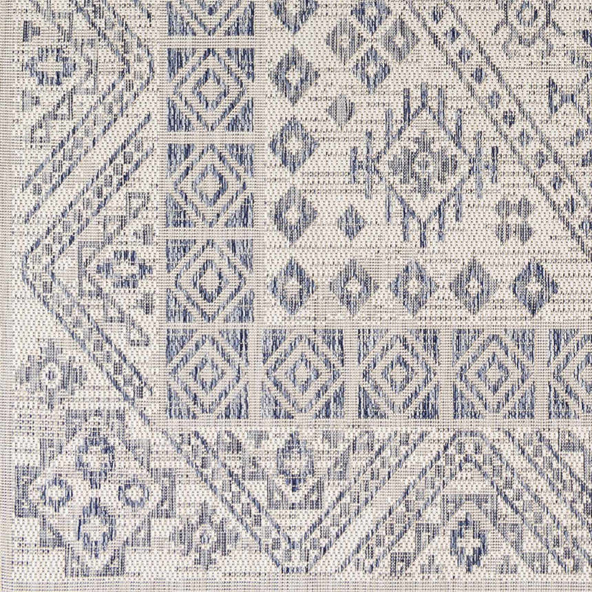 Close-up of the Balarim Indoor & Outdoor Rug, showcasing its geometric diamond pattern in charcoal and light gray. Swatch
