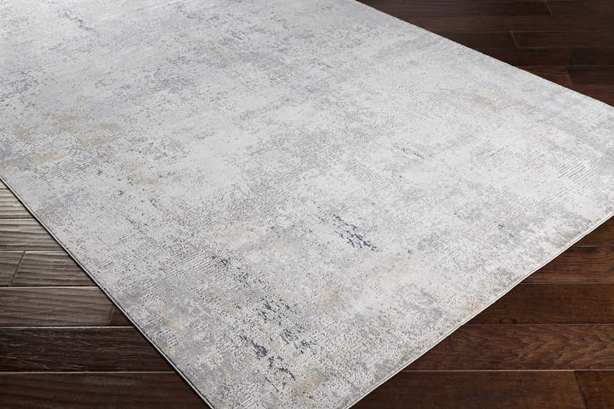Close-up of the Baranduda Abstract Gray Luxe Rug showing its charcoal, blue, beige, and yellow abstract design. Corner