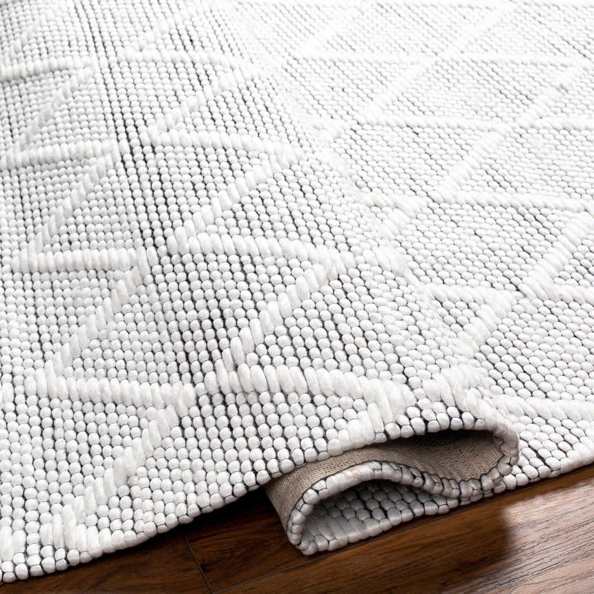 Close-up of the hand woven Bartimaeus Area Rug. Gray, nickel, and silverton rug with farmhouse style geometric pattern. Fold