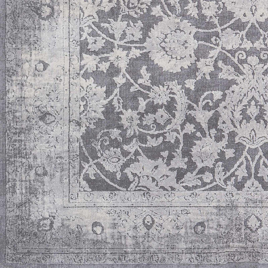 Close-up of the Benavides Gray Updated Traditional Tibetan Rug featuring a floral pattern and distressed border. Swatch