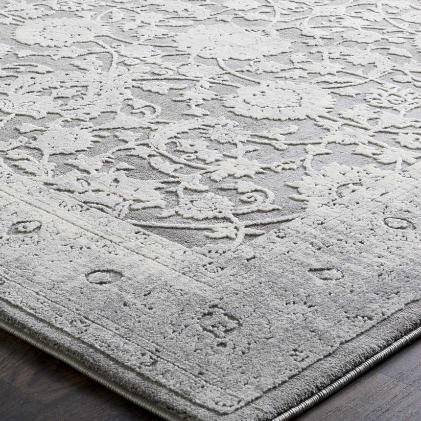 Close-up of the Benavides Gray Updated Traditional Tibetan Rug, showing its charcoal and ivory floral pattern. Texture