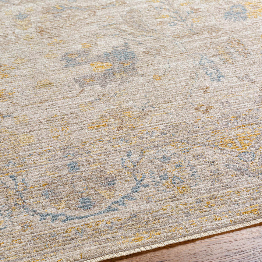 Close-up of the Berta Thick Luxe Statement Rug. Tan rug with charcoal, mustard, and blue traditional pattern. Texture