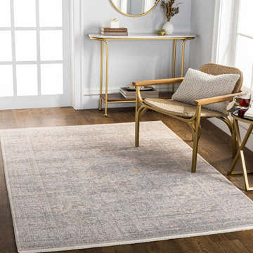 Living room scene with a light gray Beto Area Rug, gold accent table, and woven chair. Roomscene-Rectangle