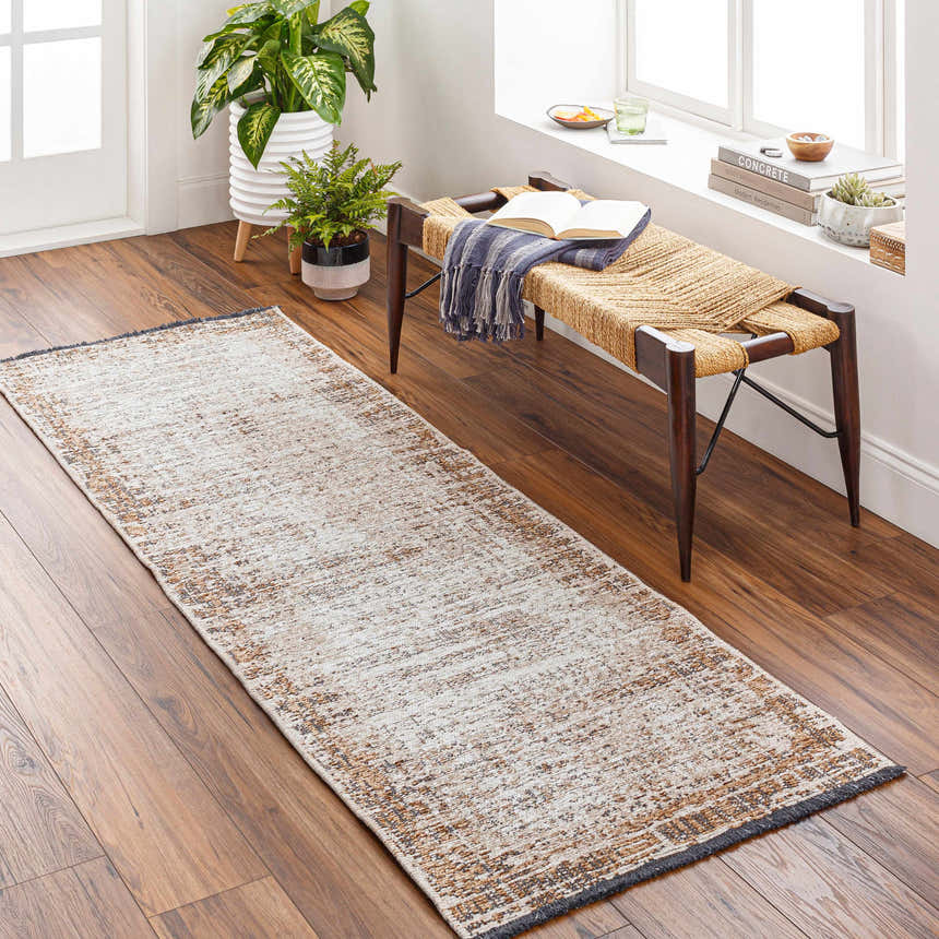 Entryway scene with Binh Rustic Brown Rug. Tan runner rug on wood floor with bench, plants, and natural light. Roomscene-Runner