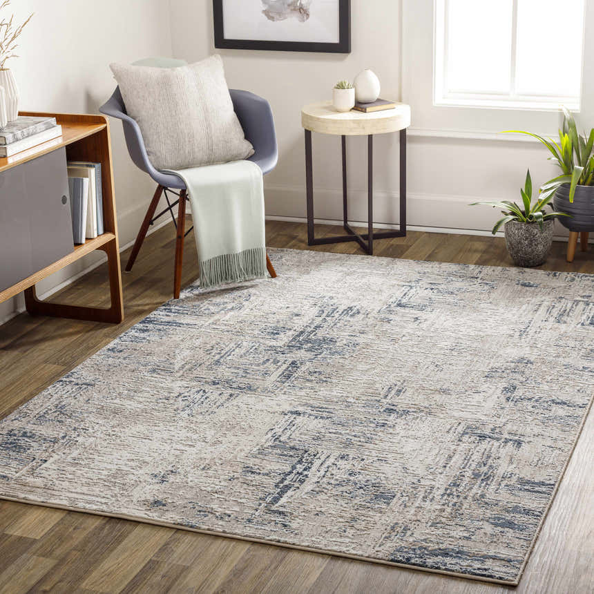 Living room scene with a gray chair and the Balasing Area Rug in dark gray, ivory, and blue tones. Roomscene-Rectangle