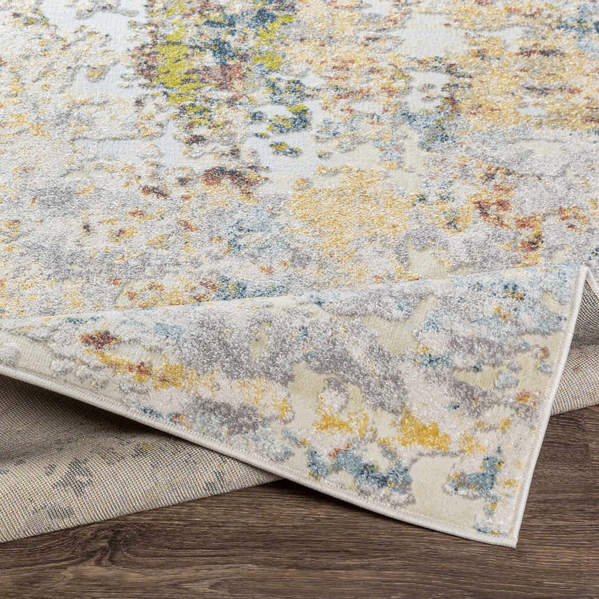 Close-up of the Bozeat Area Rug showing its charcoal, cream, olive, and rust contemporary design and polypropylene texture. Fold
