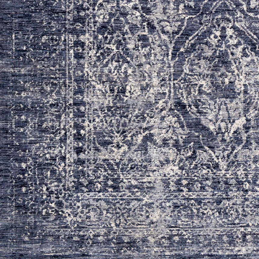 Close-up of the Barboursville Area Rug, a machine-woven polyester rug in denim, light beige, navy, pale blue, and white. Vintage style. Swatch