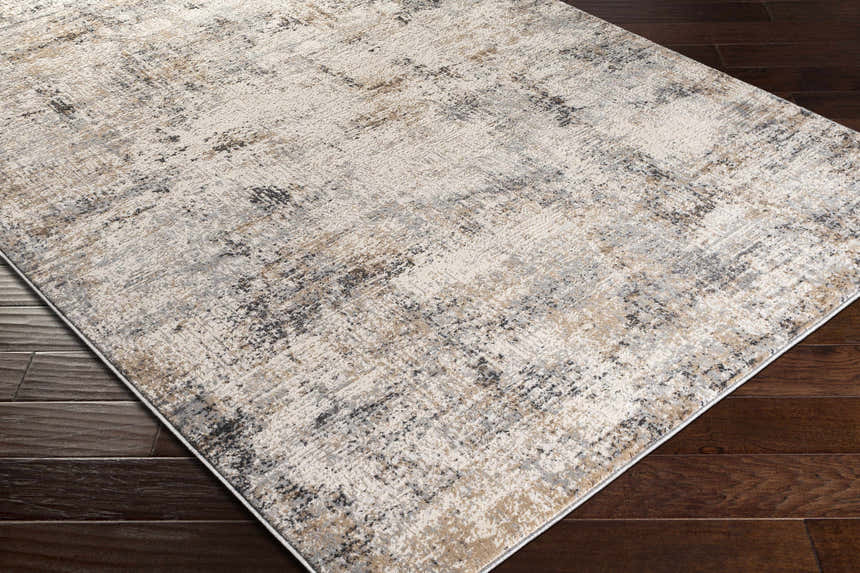 Close-up of the Braddyville Area Rug, a contemporary rug in cream, gray, black, and brown, on a dark wood floor. Corner
