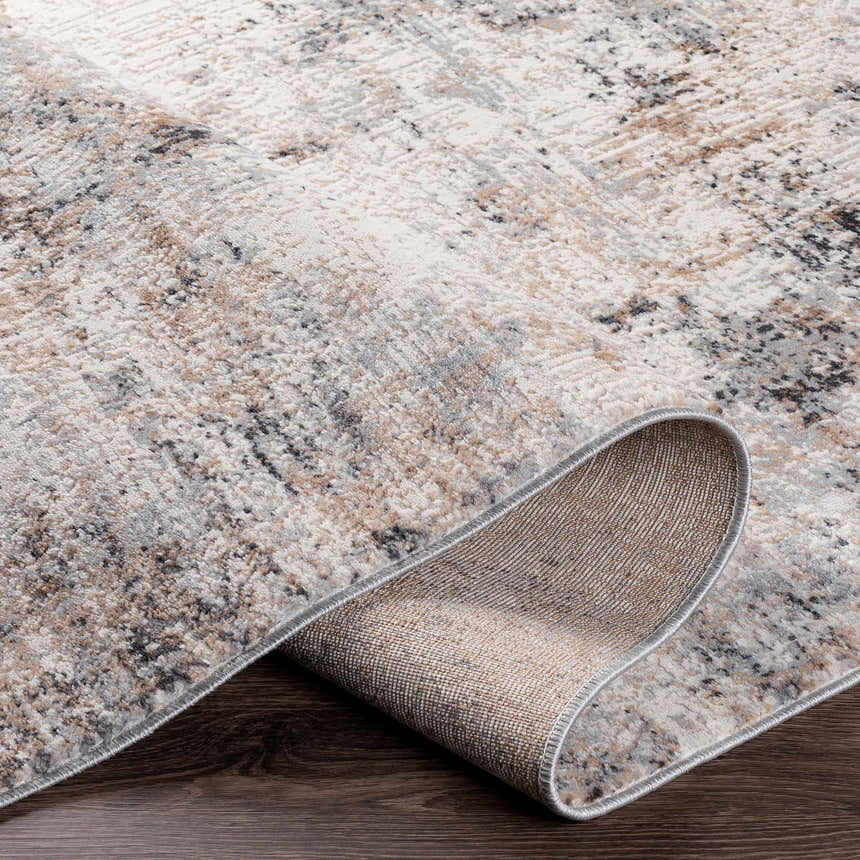 Close-up of the Braddyville Area Rug showing its contemporary design, and colors: cream, gray, tan, brown, and black. Fold