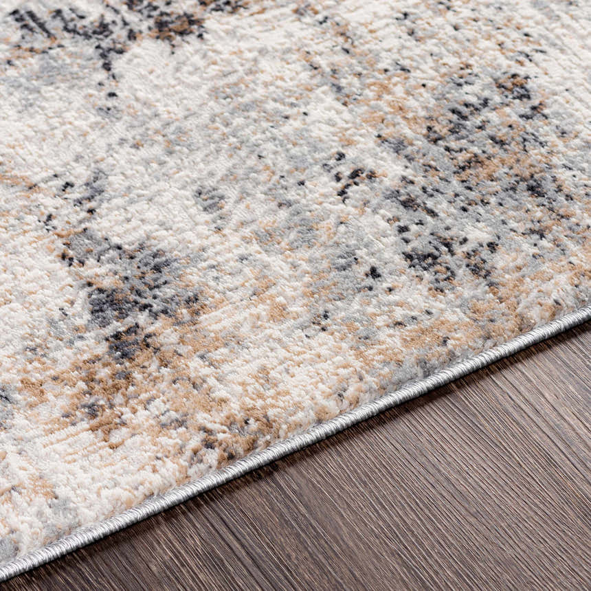 Close-up of the Braddyville Area Rug showing its contemporary black, brown, cream and gray abstract design and soft texture. Texture