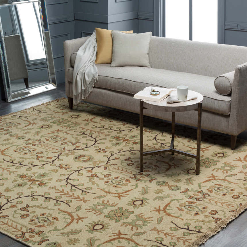 Living room scene with a traditional Brentford Carpet in oatmeal, brown, and olive tones. Wool rug complements the gray sofa and walls. Roomscene-Rectangle