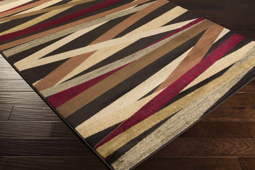 Close up of Brevard Striped Area Rug showing beige, brown, red, and gray stripes on dark wood floors. Corner