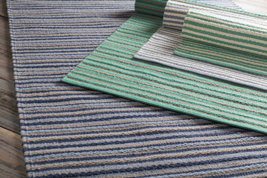 Close-up of the hand woven Bergheim Area Rug. Striped pattern in aqua, medium gray, and seafoam. 100% wool texture. Styleshot
