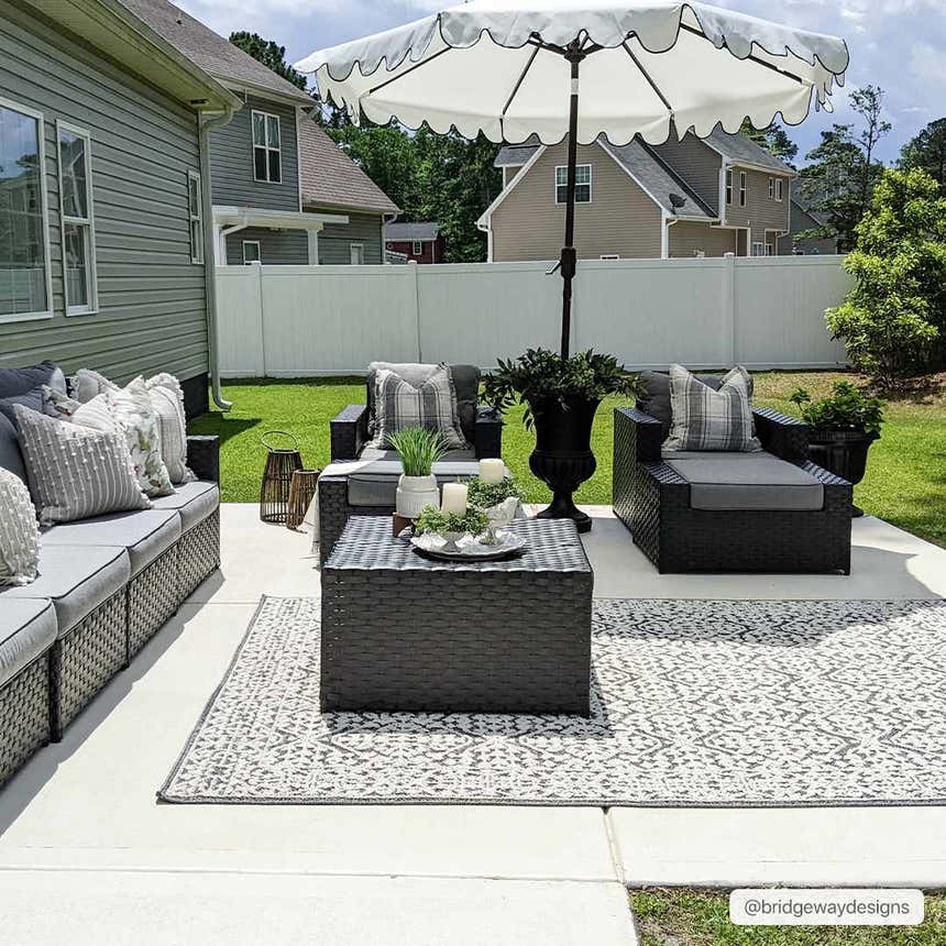 Outdoor patio scene with black wicker furniture and the black and white Kinglake Area Rug. Roomscene-Rectangle