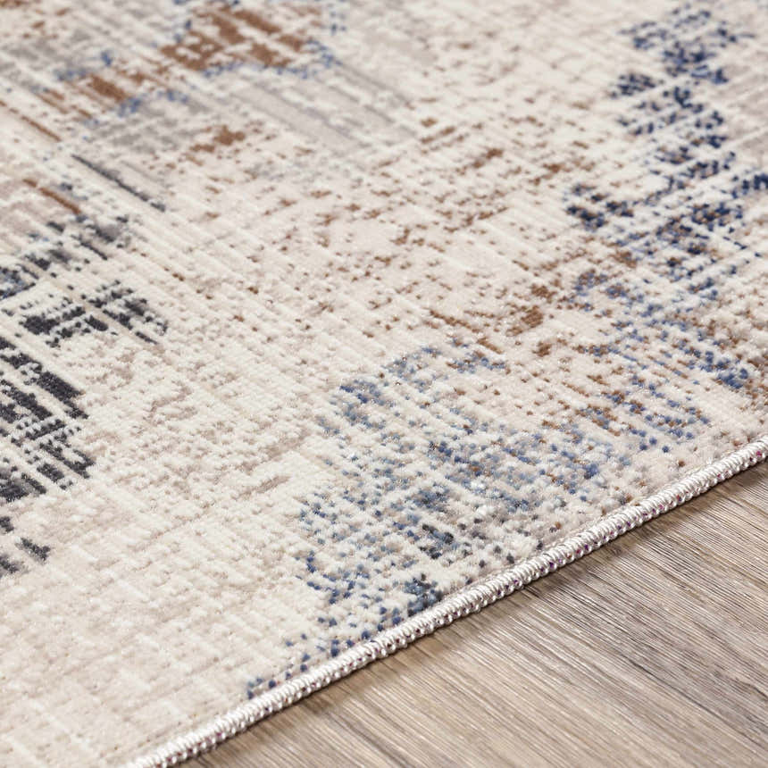 Close-up of the Buckner Blue Ikat Rug showing its navy, brown, and gray bohemian pattern and soft texture. Texture