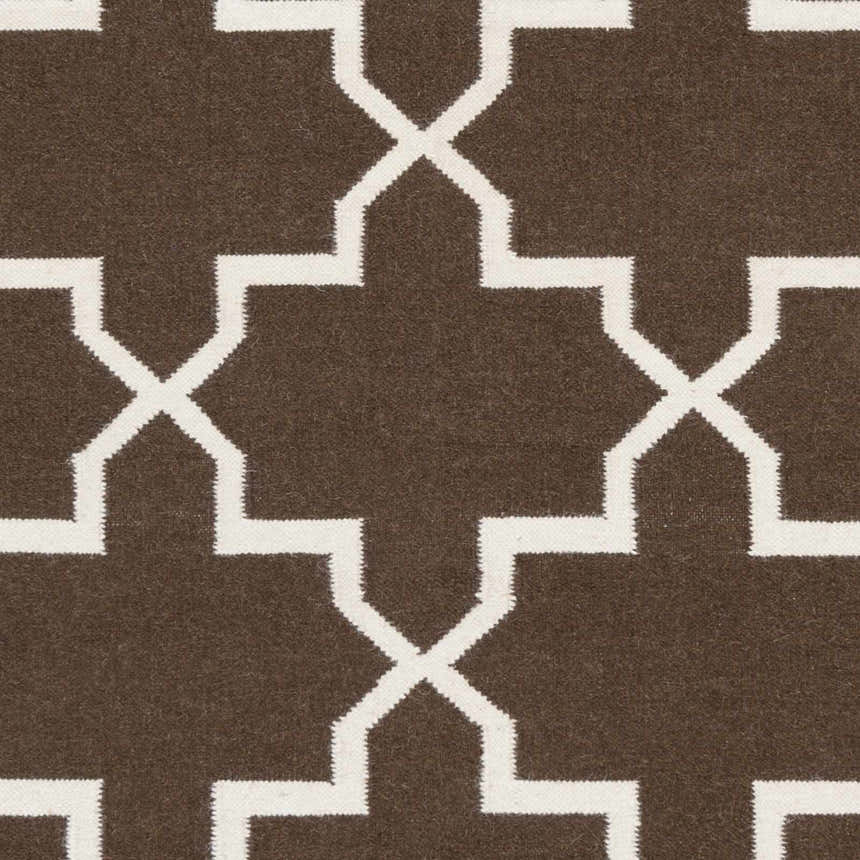 Close-up of Bullock Area Carpet showing dark brown wool and ivory geometric pattern. Hand woven texture. Swatch