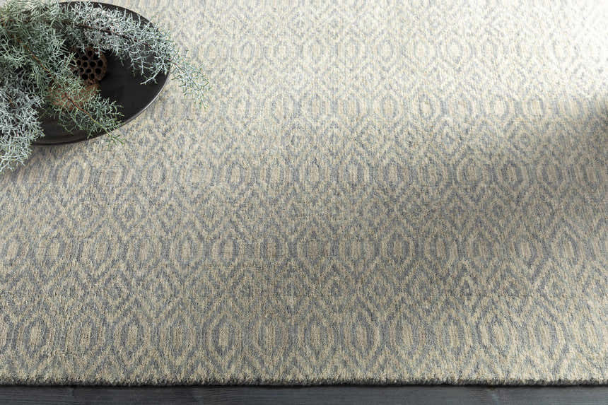 Close up of the Bumpass Area Rug. Light sage and medium gray wool rug with a geometric diamond pattern. Styleshot