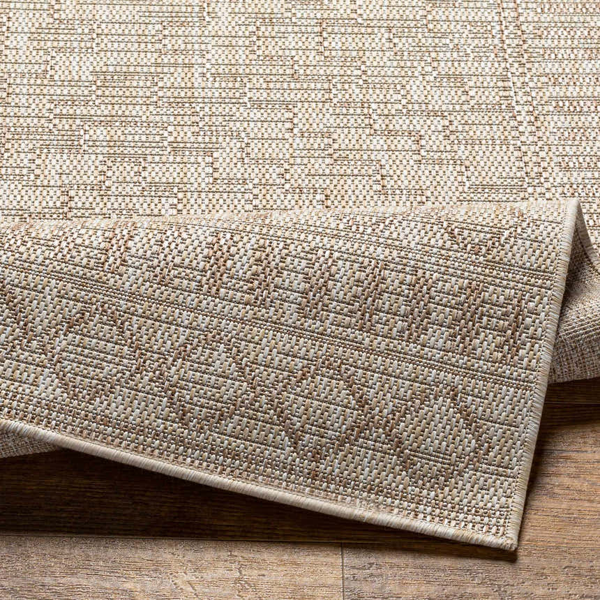Close-up of the Buninyong Indoor & Outdoor Rug. Farmhouse style rug in dark gray, gray, and brown tones. Polypropylene material. Fold