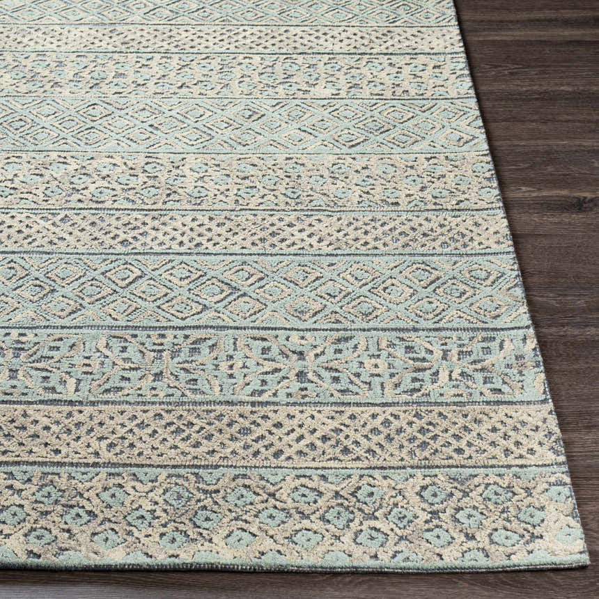 Close-up of the hand-tufted Byron Area Rug. Bohemian style with beige, charcoal, sage, and taupe geometric patterns. Front