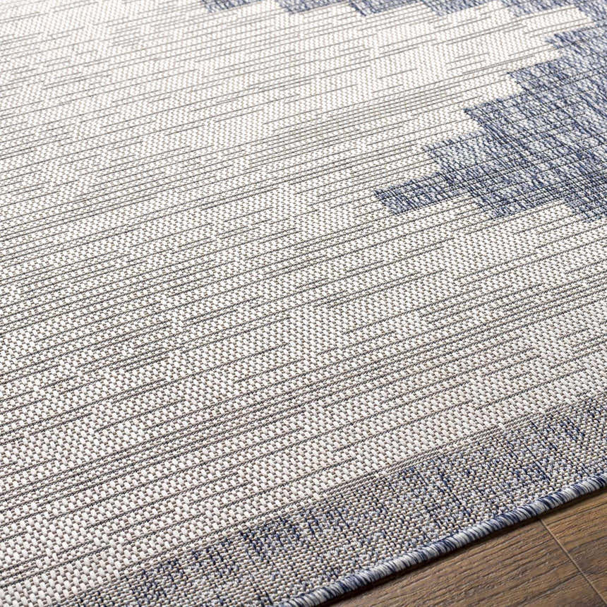 Close-up of the Djugun Blue Outdoor Rug showing its woven texture and geometric pattern in blue, gray, and off-white. Texture