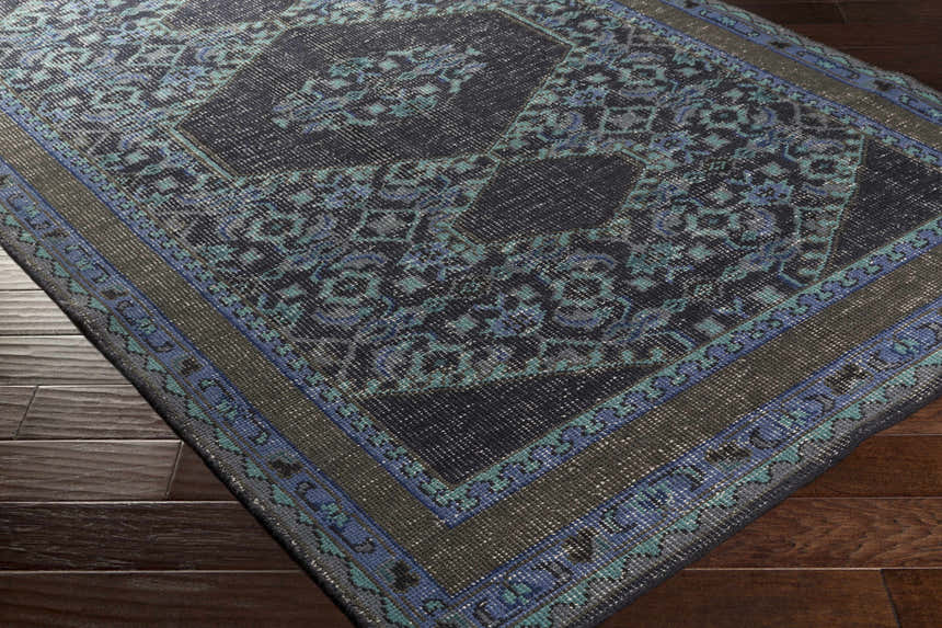 Close-up of the hand-knotted Chesham Clearance Rug. Traditional style with charcoal, blue, and teal floral pattern. Corner