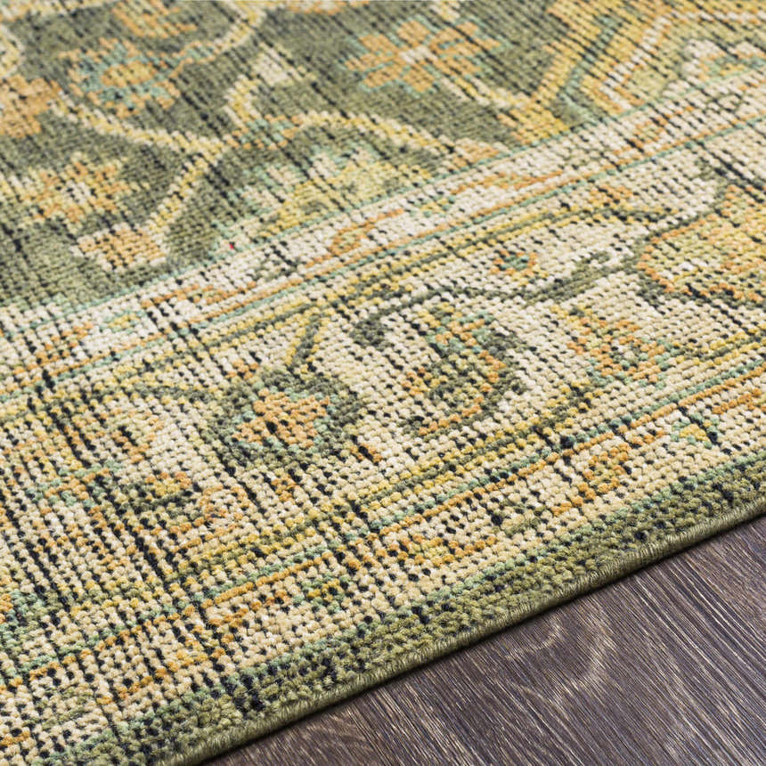 Close-up of the hand-knotted Clunes Area Rug. Wool rug with a traditional pattern in grass green, yellow, light beige, and black. Texture