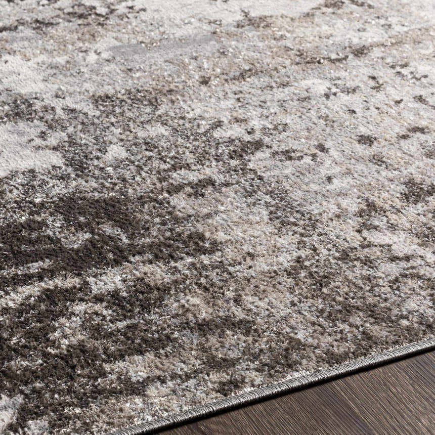 Close up of the charcoal, gray, and light gray Calvinia Area Rug. Contemporary style, machine woven texture. Texture