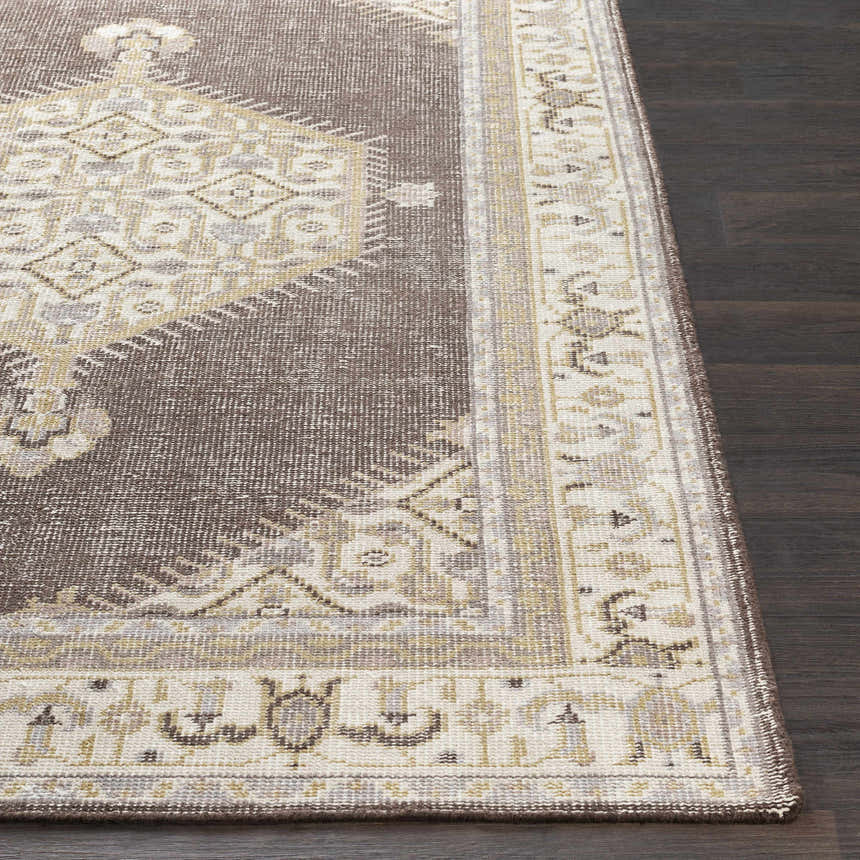 Close-up of the Clyo Carpet, a hand-knotted wool rug in brown, off-white, and gray on dark wood flooring. Front